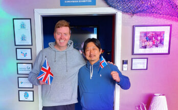 Orly Orlyson and Hiroshi Katta with the flags of Iceland and the UK in front of the Húsavík Eurovision Exhibition