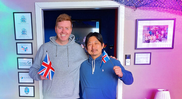 Orly Orlyson and Hiroshi Katta with the flags of Iceland and the UK in front of the Húsavík Eurovision Exhibition